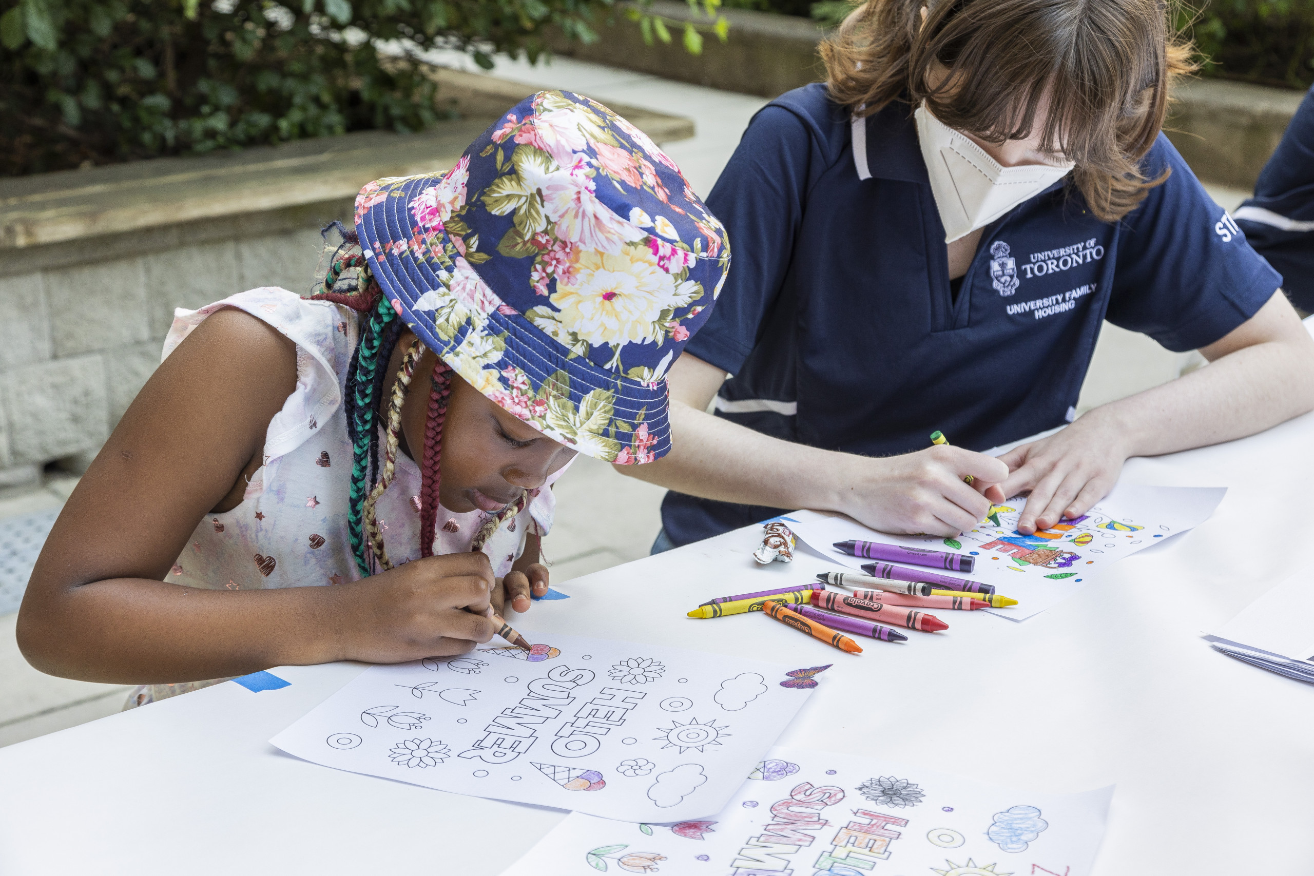 child and staff colouring at garden party